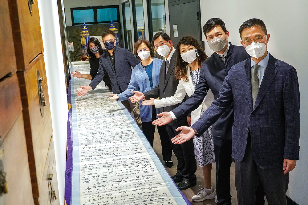 楊潤雄局長在全球最長中文手抄聖經《絲綢聖經》前留影，該卷聖經全長5000米。 