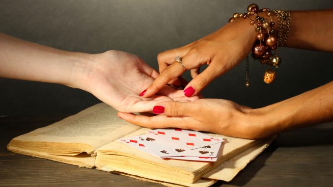 reading the lines hand in a woman's hands on grey backcground